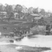 Public baptism in progress below old mill bridge - around 1900